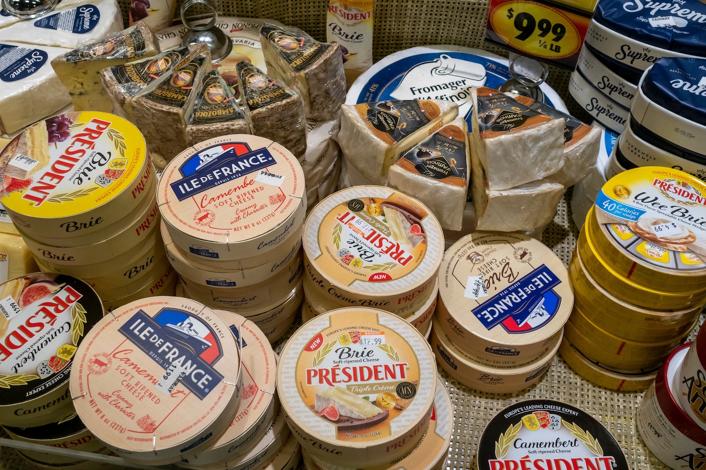 Wheels of brie cheese in a supermarket display