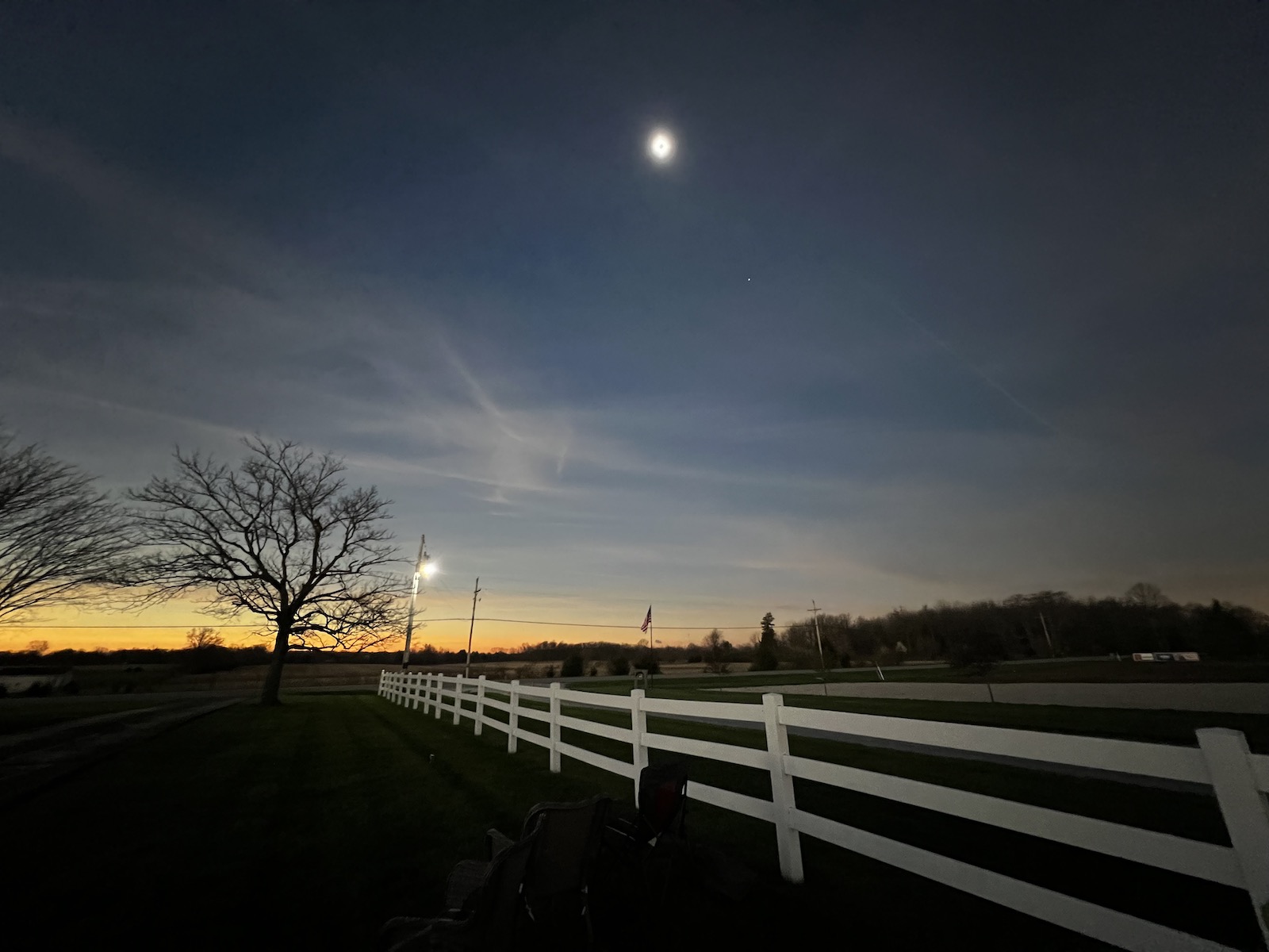 Eclipse totality and a 360 sunset over a white fence
