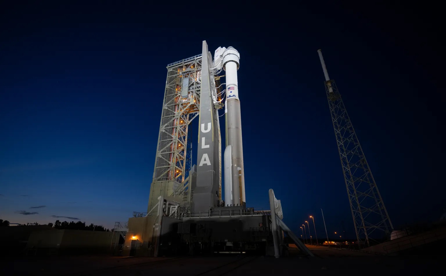 A rocket prepared for launch at night.