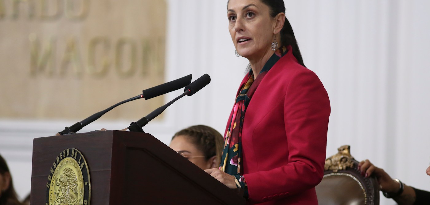 A woman, Claudia Sheinbaum Pardo, stands at a podium giving a speech.