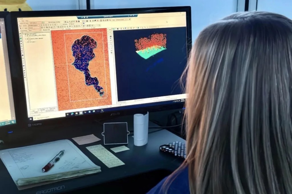 A person at a computer with elevation charts on it.