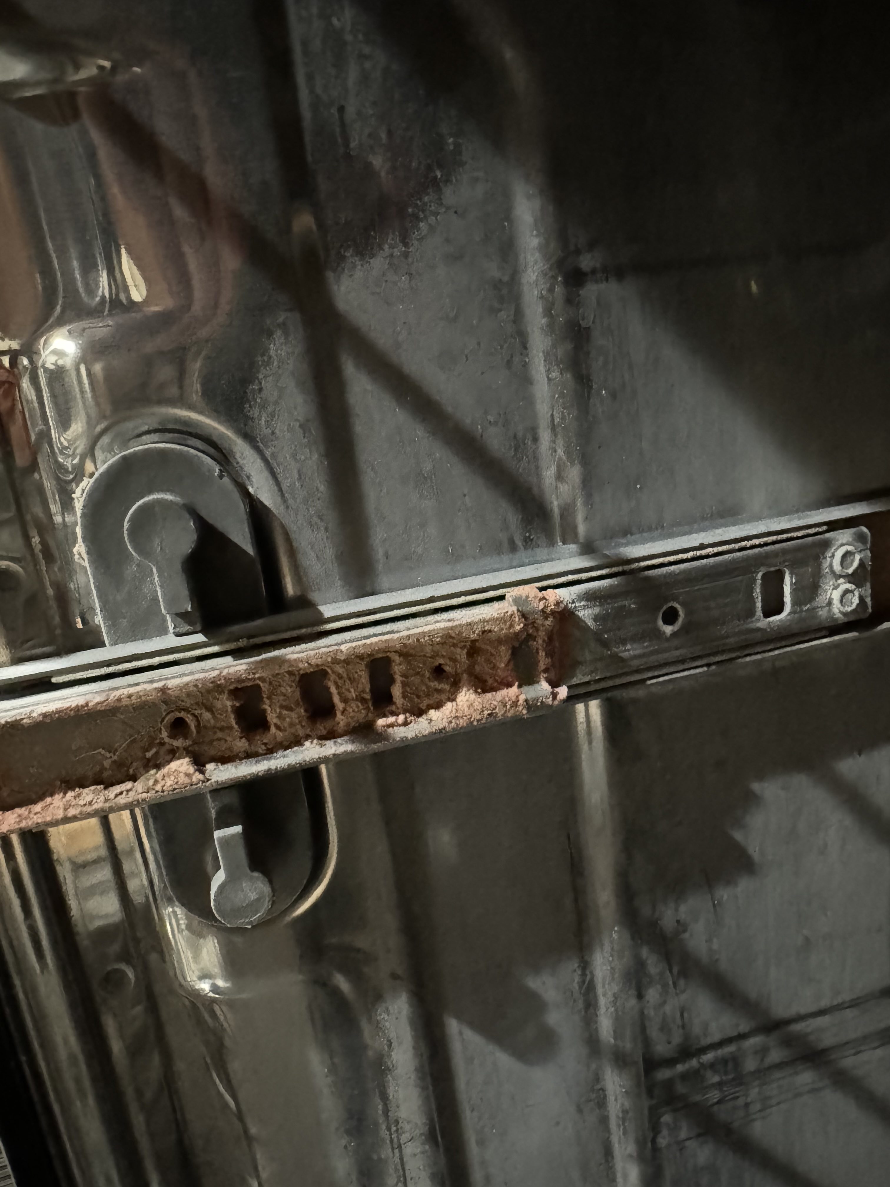A metal latch covered in crust.