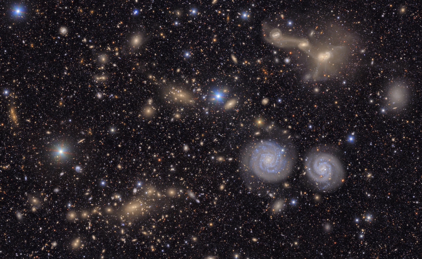 Visible are two prominent spiral galaxies, three merging galaxies, galaxy groups both near and distant, stars within our own Milky Way, and much more.