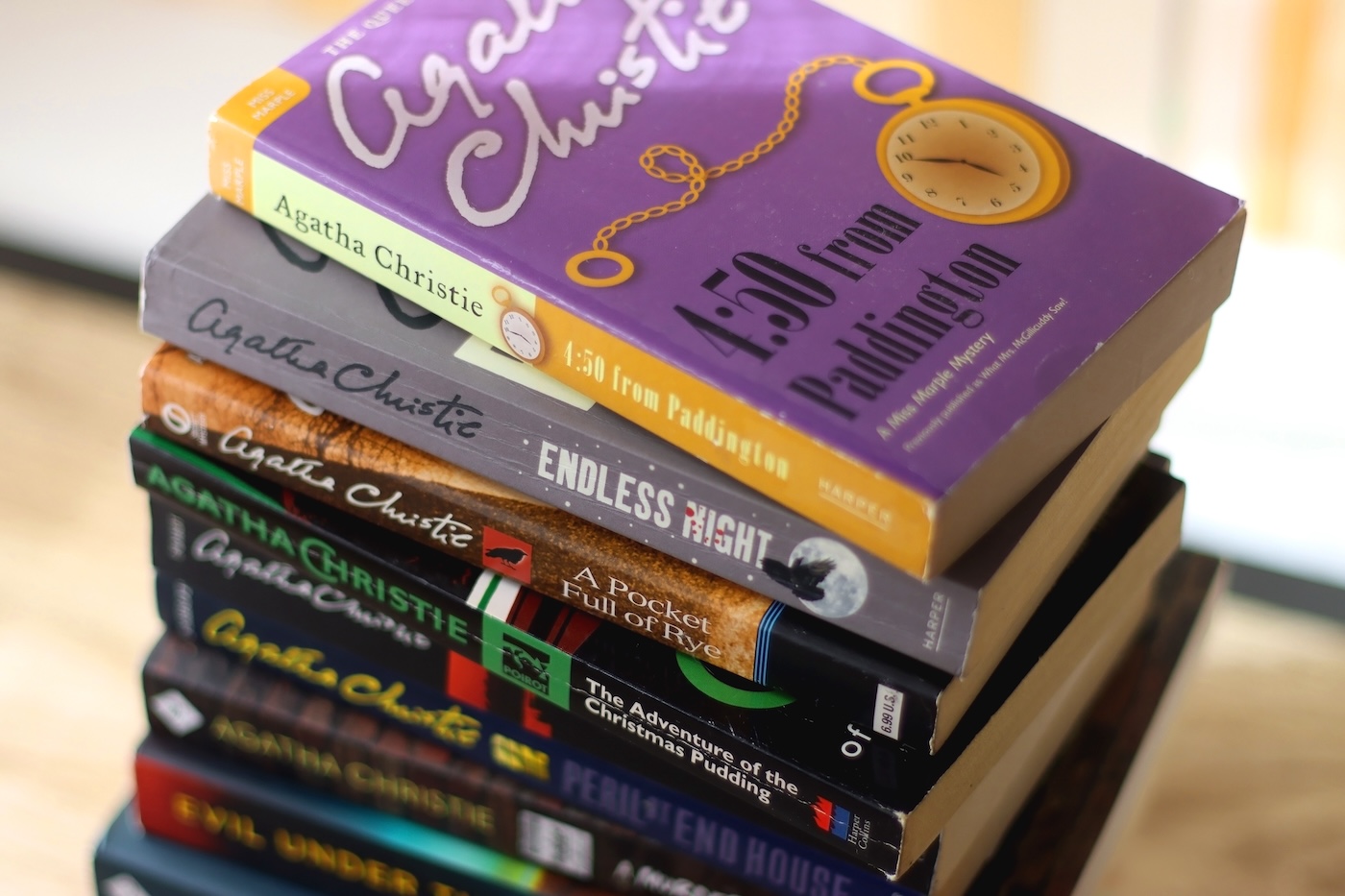 Split, Croatia - January 15, 2023: Stack of murder mystery books by famous author Agatha Christie. Bookshelf in the background. Selective focus.