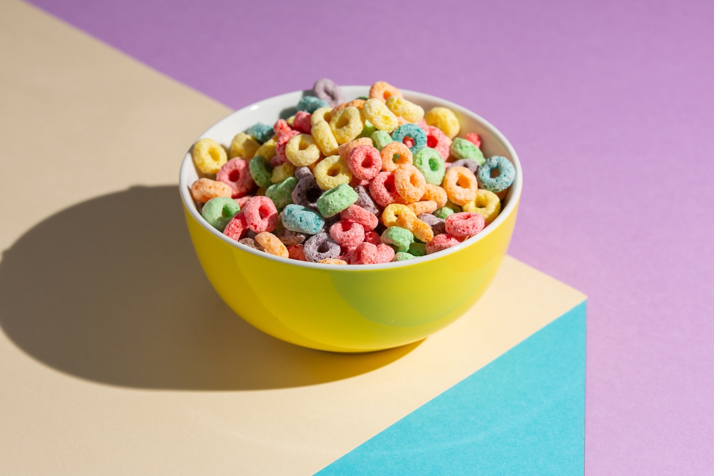 cup with froot loop cereal in a colored bowl, with a colorful background
