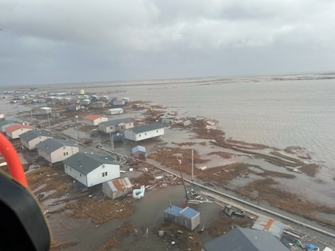 An aerial view of a completely flooded areas, where roads and homes are damaged.