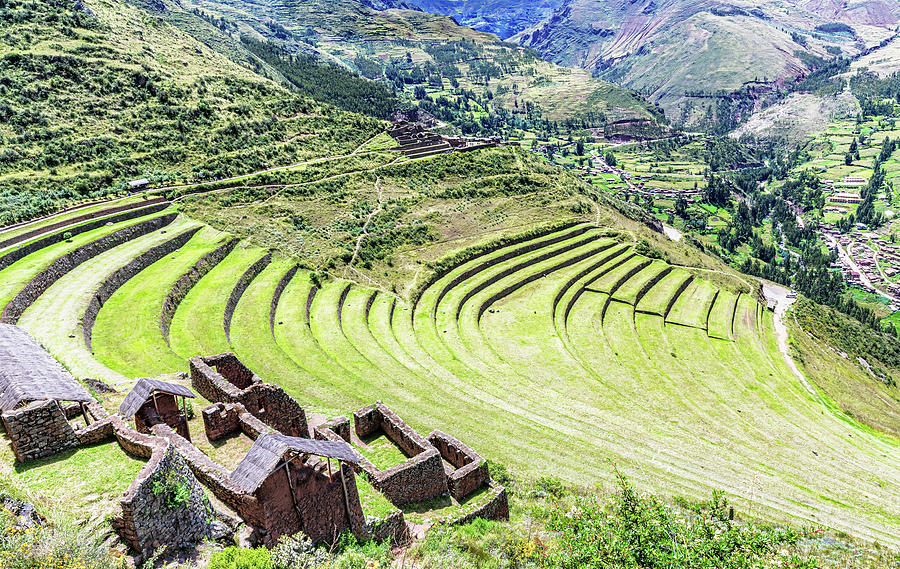 Ancient agricultural terraces carved into Andean hillsides in concentric circular patterns with stone retaining walls, showing traditional farming methods.