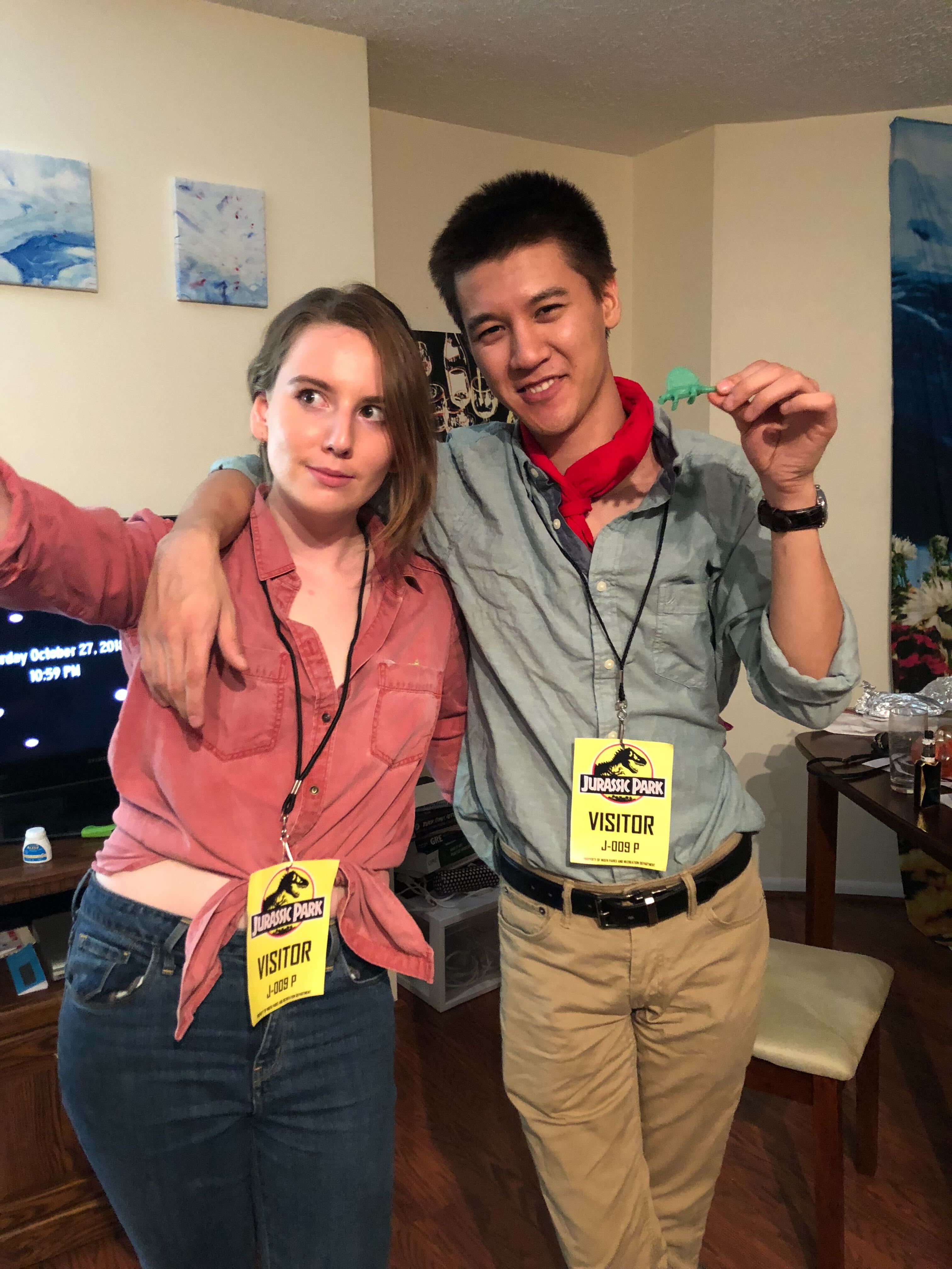 Two people wearing lanyards that say "Jurassic Park Visitor"