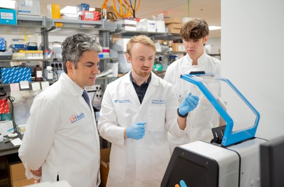 Three men in a lab processing samples.