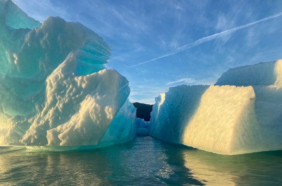 A large iceberg floating by the edge of a glacier