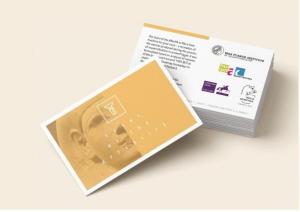A stack of white postcard with text and logos on the back. One is flipped, showing a yellow front with a mummy head image and "Scent of the Afterlife"
