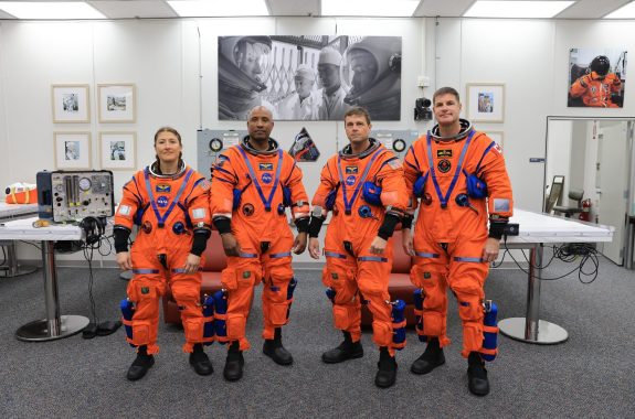 From left, Artemis II Mission Specialist Christina Koch, Pilot Victor Glover, and Commander Reid Wiseman, from NASA, along with Mission Specialist Jeremy Hansen from the CSA (Canadian Space Agency) complete leak checks on their spacesuits inside the crew suit-up room at the agency’s Kennedy Space Center in Florida on Wednesday, April 1, 2026, ahead of the Artemis II test flight.