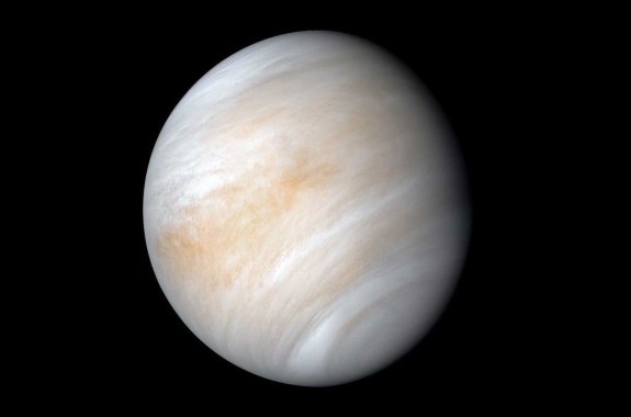 A white planet with wispy pinkish coloration against a black background