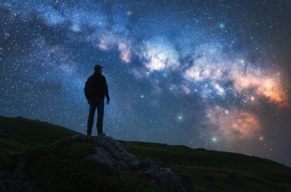 Silhouette of a guy on the hill, sky with bright stars