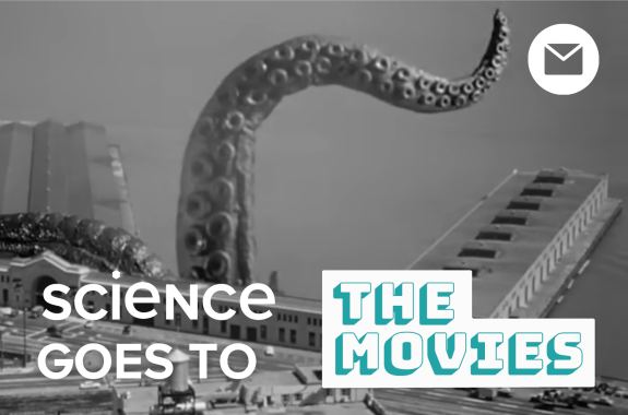 Black-and-white image of a giant octopus arm waving in the air over a San Francisco building