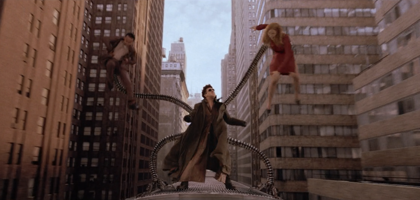 A man holds a woman and a man in the air with metal tentacles extending from his back.